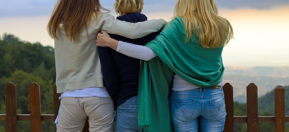 a group of three women standing next to each other